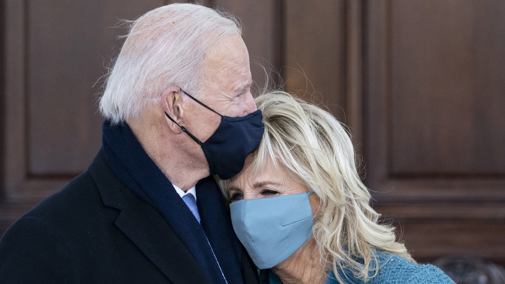 President Joe and Jill Biden hugging each other with masks on 