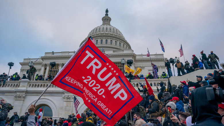 January 6 insurrectionists carrying a Trump flag