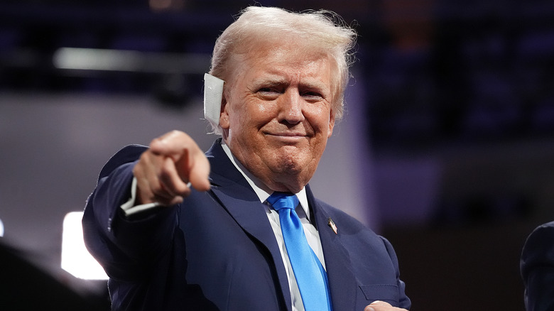 Donald Trump smiling and pointing with bandaged ear