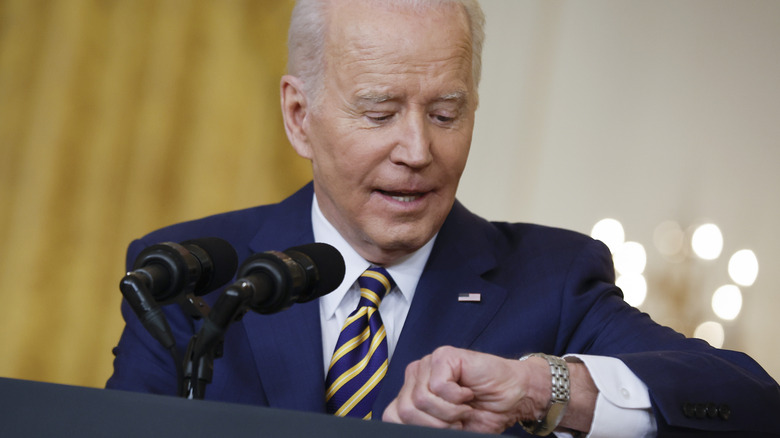 President Joe Biden checking watch at long press conference