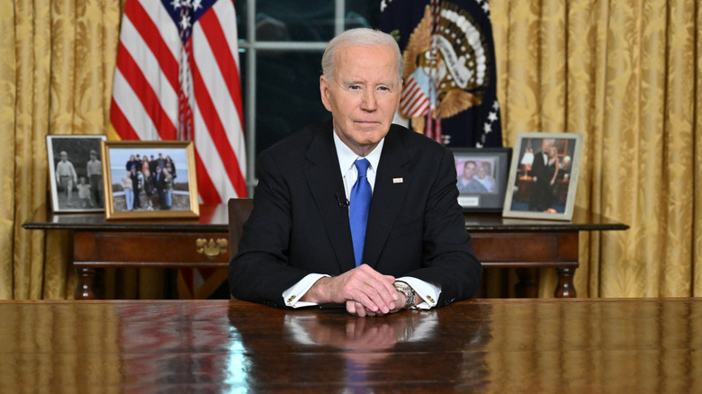 Joe Biden sitting behind his desk in the Oval Office