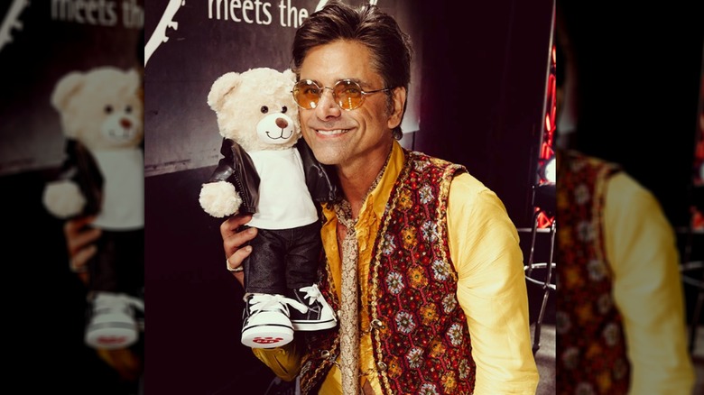 John Stamos holding a teddy bear 