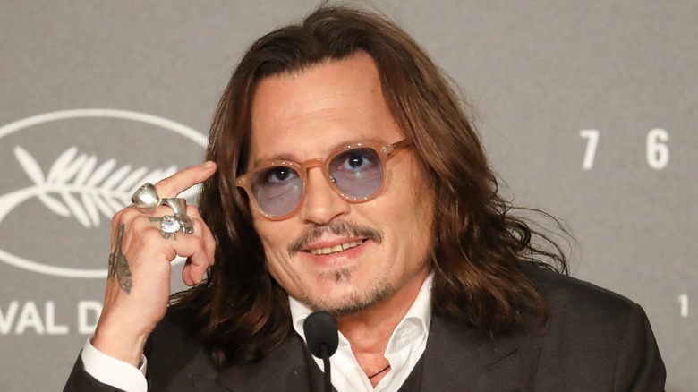 Johnny Depp smiling at a Cannes press conference