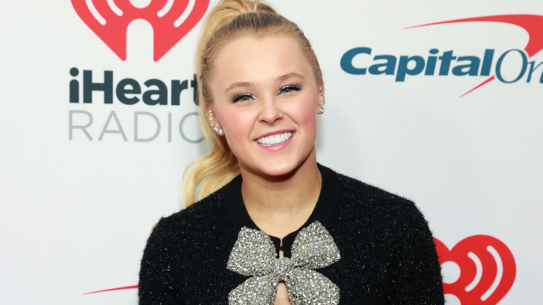 Jojo Siwa wearing a bow tie shirt on the red carpet