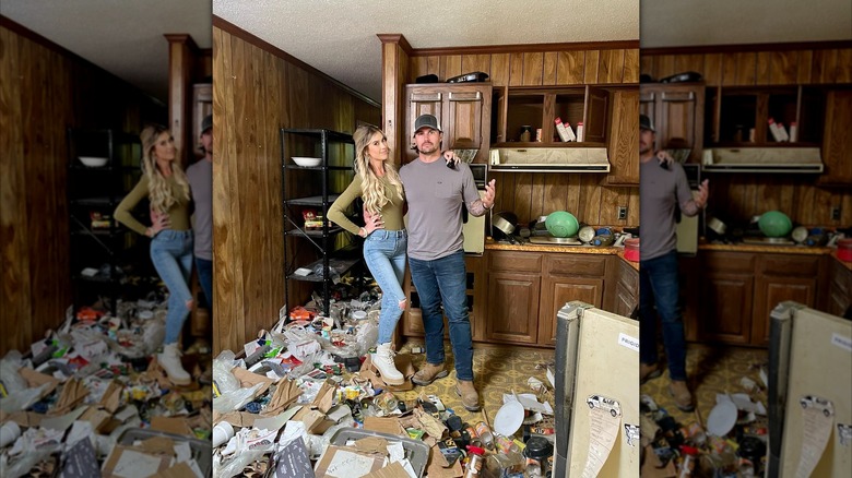 Christin and Josh Hall posing together in a trashed house