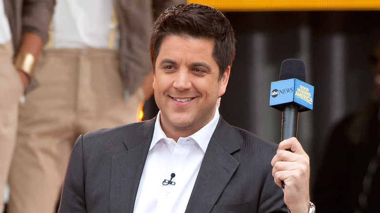 Josh Elliott holding a microphone