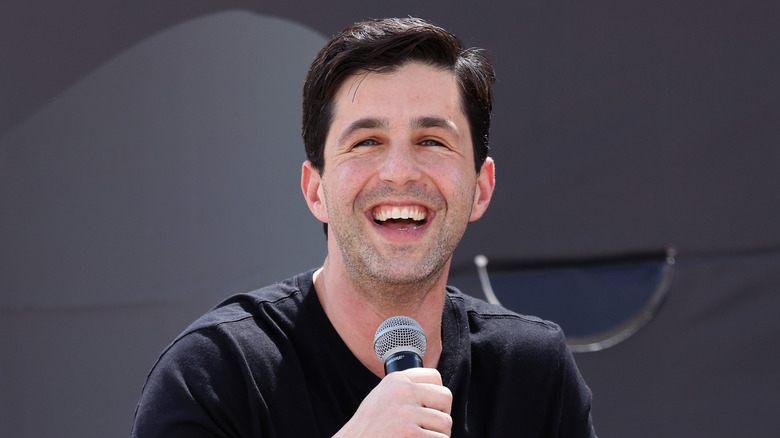 Peck smiling holding microphone