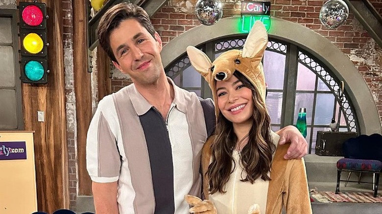 Josh Peck and Miranda Cosgrove smiling on set