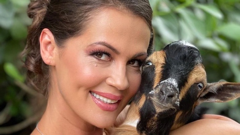 Julia Lemigova holding a goat