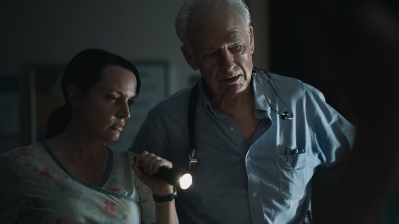 Diane holding a flashlight standing with a doctor