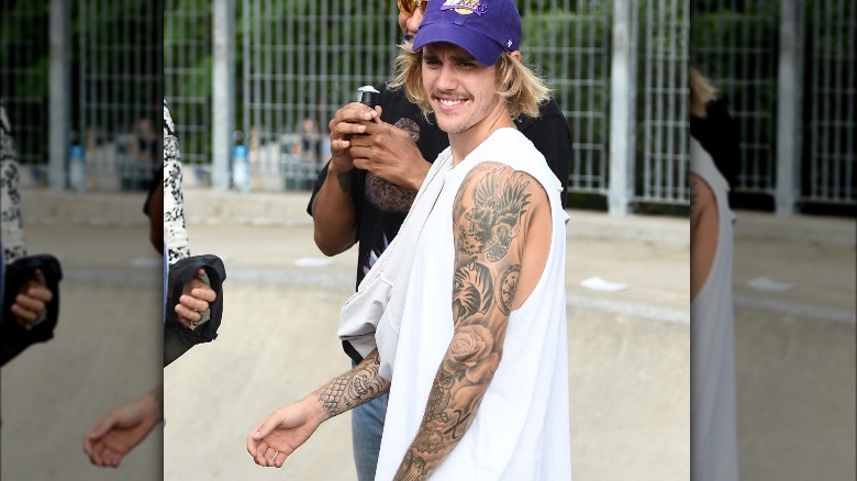 Justin Bieber showing off his arm tattoos in a tanktop