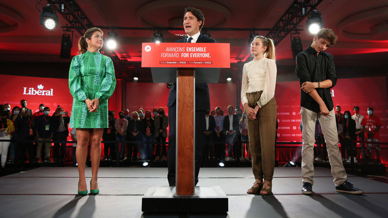 Justin Trudeau standing at a podium, surrounded by Sophie Grégoire Trudeau and their children Ella-Grace and Xavier