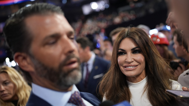 Kimberly Guilfoyle smiling at an out of focus Donald Trump Jr.