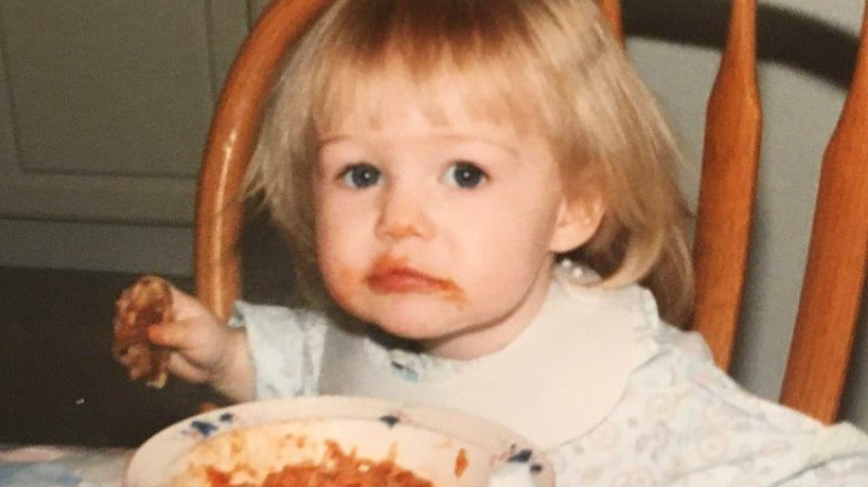 Toddler Kris Collins sitting at dinner table