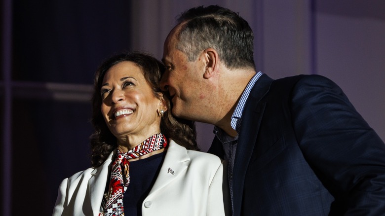 Douglas Emhoff whispering to Kamala Harris