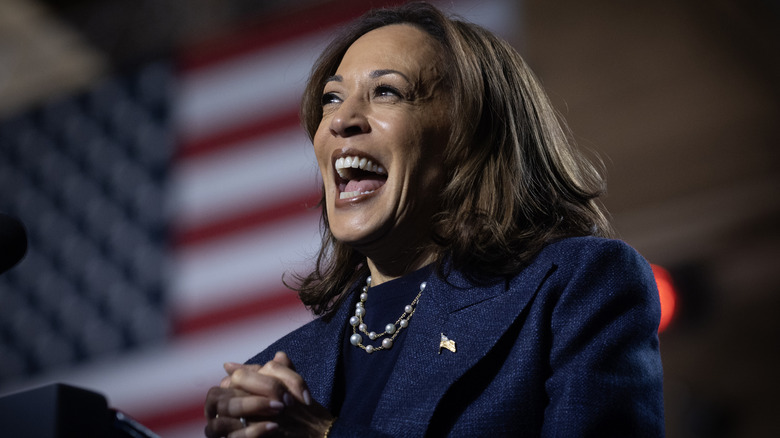 Kamala Harris laughing with an American flag in the background