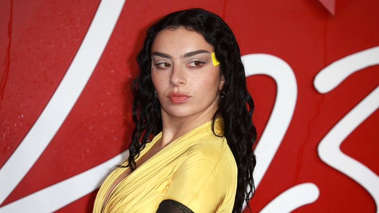 Charli XCX posing in yellow shirt