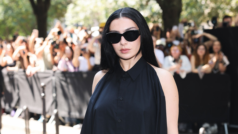 Charli XCX in dark shades and a black dress