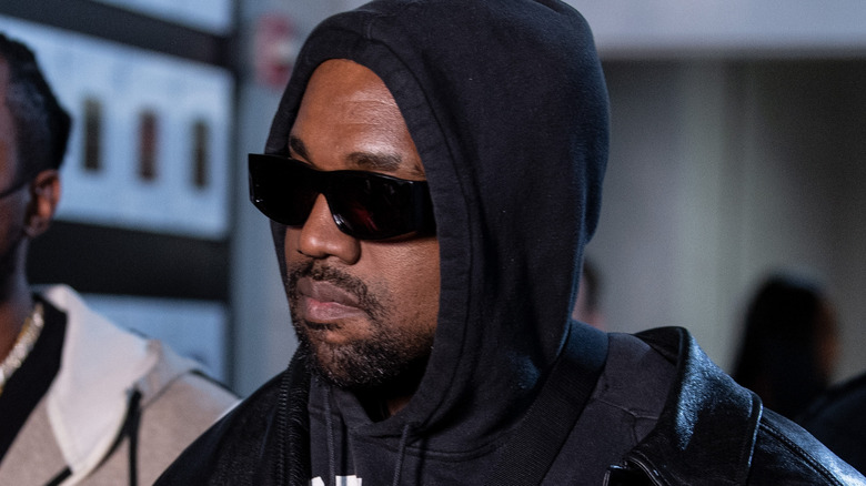 Kanye West wearing a hoodie and sunglasses