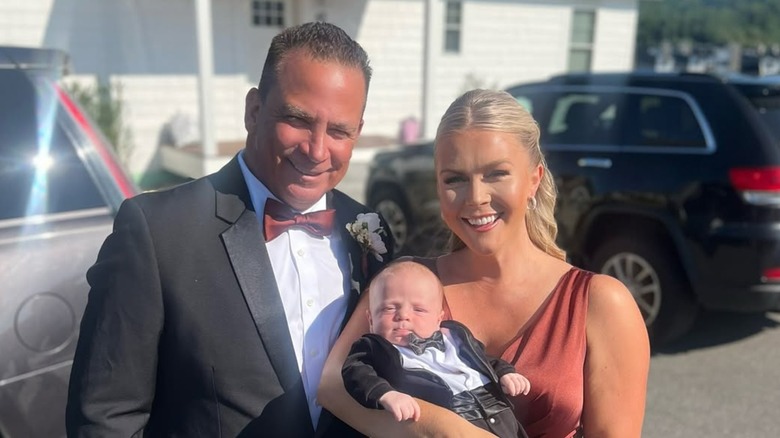 Karoline Leavitt and Nicholas Riccio smiling while holding their baby