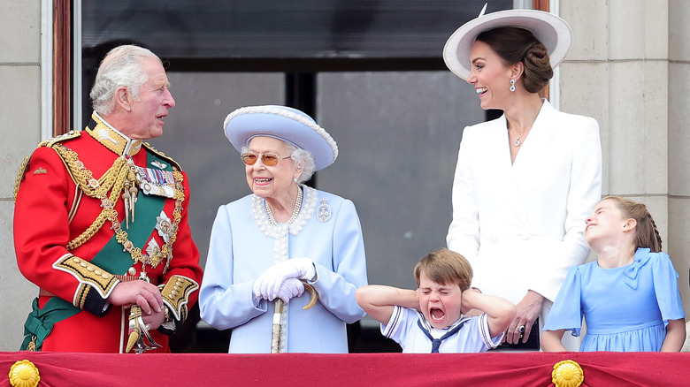 Prince Charles, the queen, Kate Middleton and Princess Charlotte look on as Prince Louis freaks out