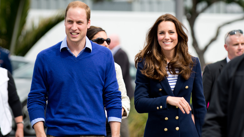 Prince William and Kate Middleton smiling and walking