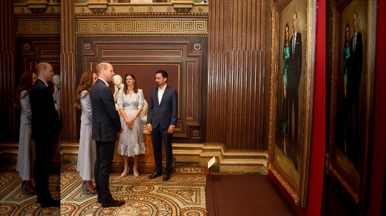 Prince William and Kate Middleton looking at their first joint portrait