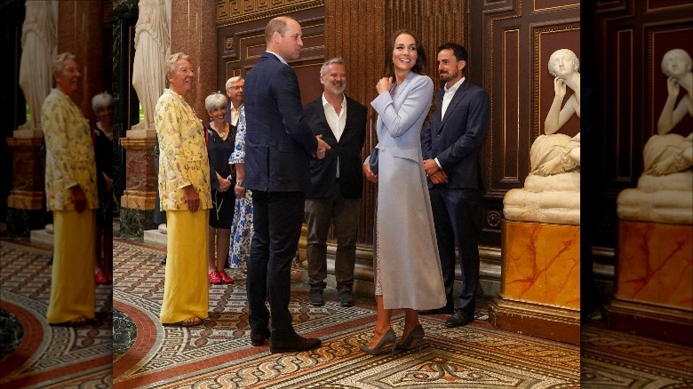 Kate Middleton stealing a look at the first joint portrait of her and Prince William