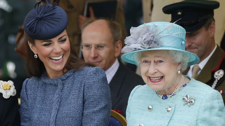 Kate Middleton and Queen Elizabeth seated laughing 