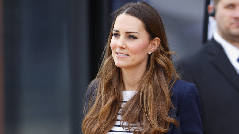 Kate Middleton looking serious and wearing stripes