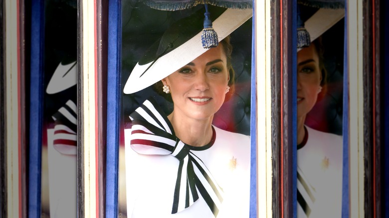 Kate Middleton smiling and wearing a stripey bow