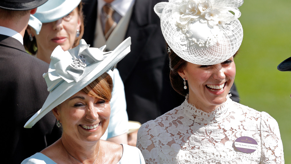 Kate Middleton's smiling in white hat and her mother Carole Middleton