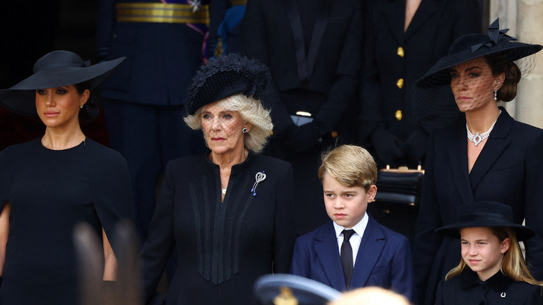 Meghan, Camilla, George, Kate, and Charlotte looking somber