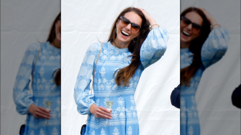 Kate Middleton smiling, holding champagne