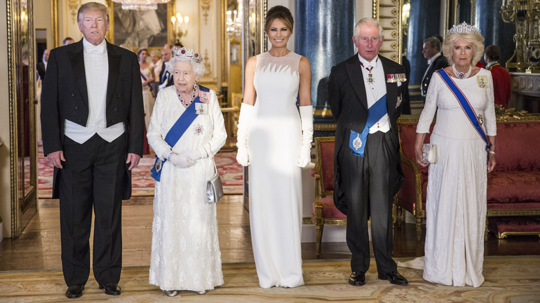 Donald Trump standing alongside Queen Elizabeth, Melania Trump, King Charles, and Queen Camilla