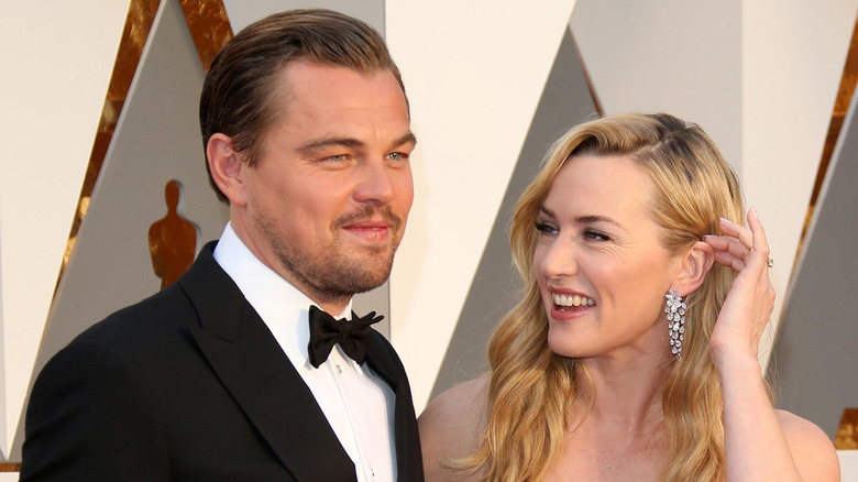 Kate Winslet smiling while looking at Leonardo DiCaprio at the Oscars