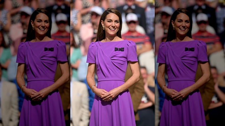 Kate Middleton with her hands on her stomach