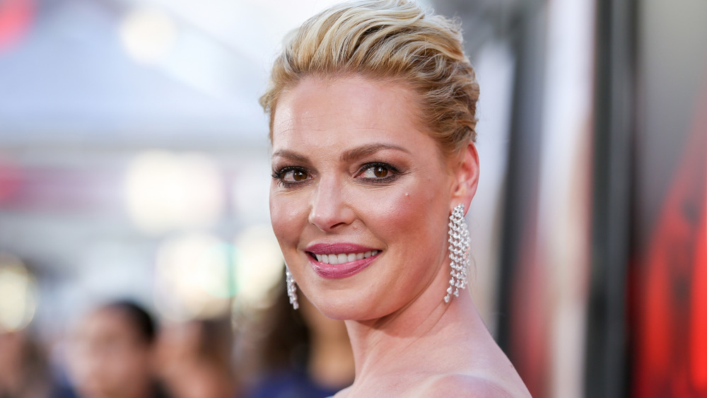 Katherine Heigl smiling with drop earrings and hair up