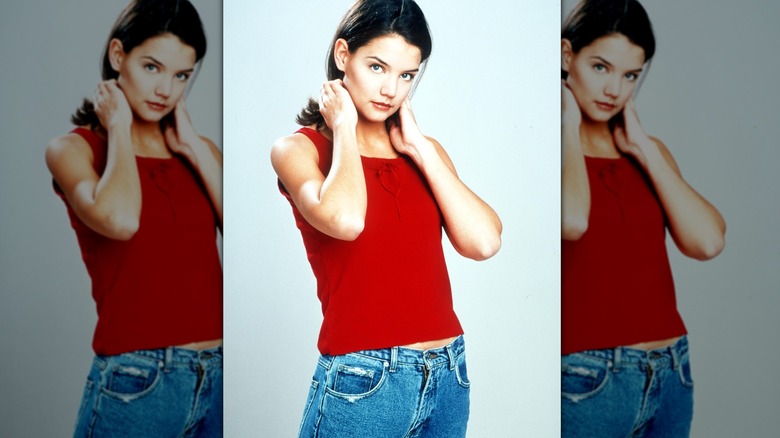 Katie Holmes in a press still for Dawson's Creek wearing a red top and jeans