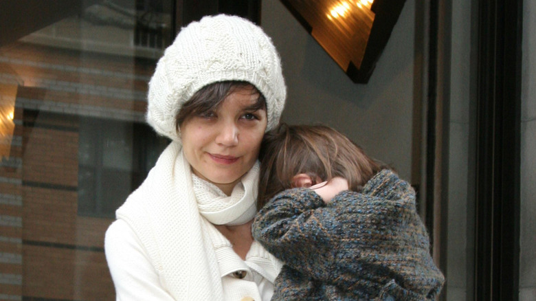 Katie Holmes smiling while holding Suri Cruise