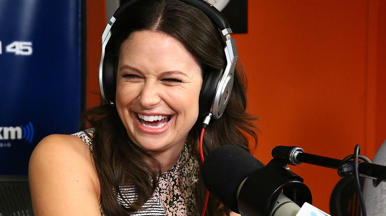 Katie Lowes laughing at a microphone