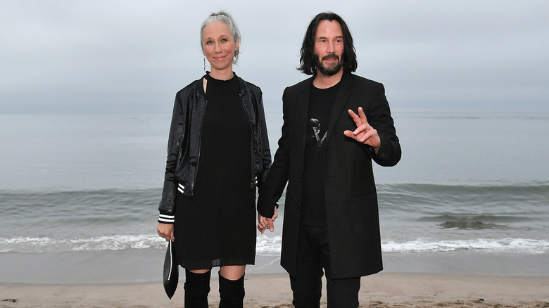 Alexandra Grant and Keanu Reeves holding hands 