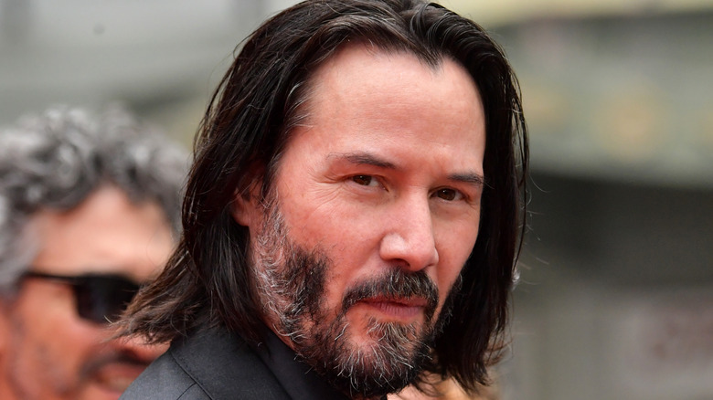 Keanu Reeves looks over his shoulder