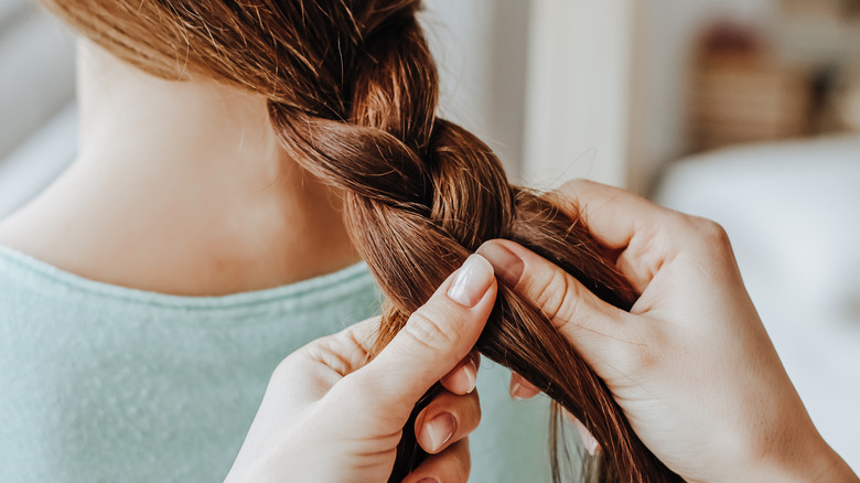 Woman braiding a girl's hair