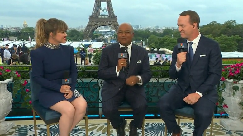 Kelly Clarkson, Mike Tirico, and Peyton Manning in front of the Eiffel Tower