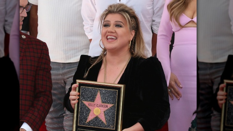 Kelly Clarkson posing with her star on the Walk of Fame