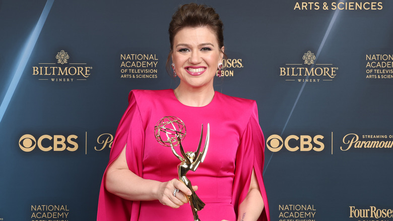 Kelly Clarkson posing with an Emmy