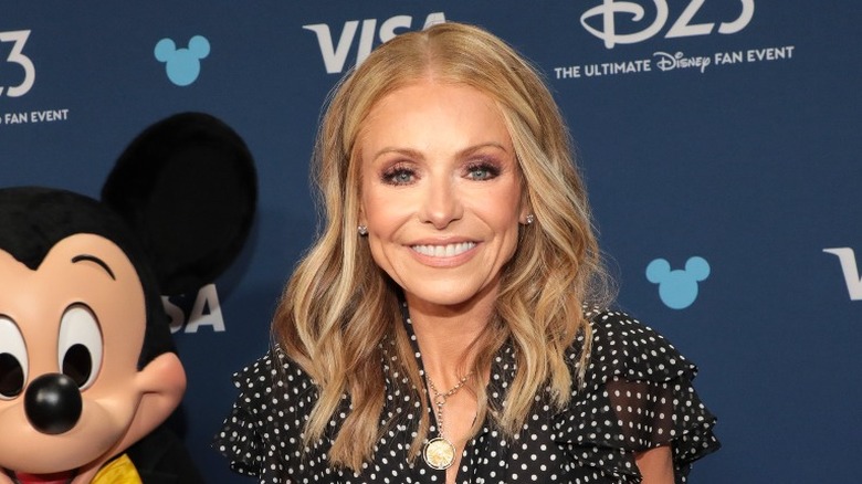 Kelly Ripa smiling next to Mickey Mouse at D23