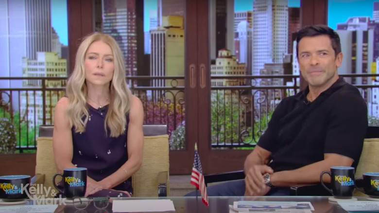 Kelly Ripa and Mark Consuelos staring into audience