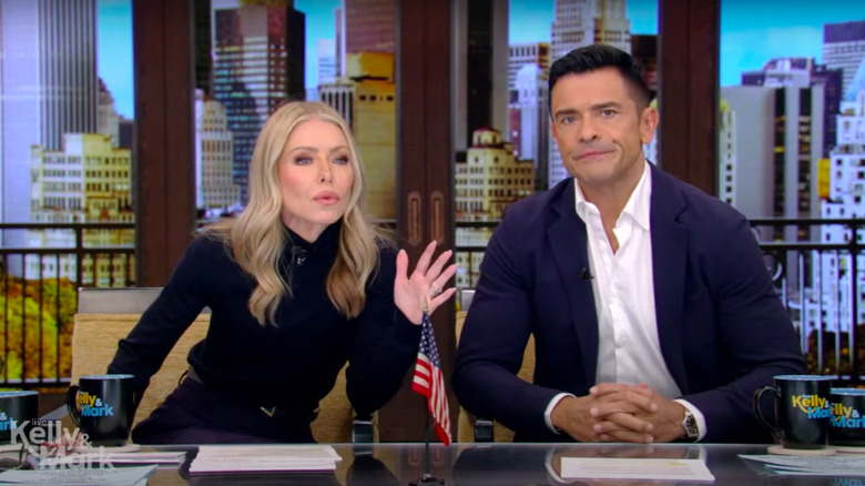 Kelly Ripa and Mark Consuelos staring at audience